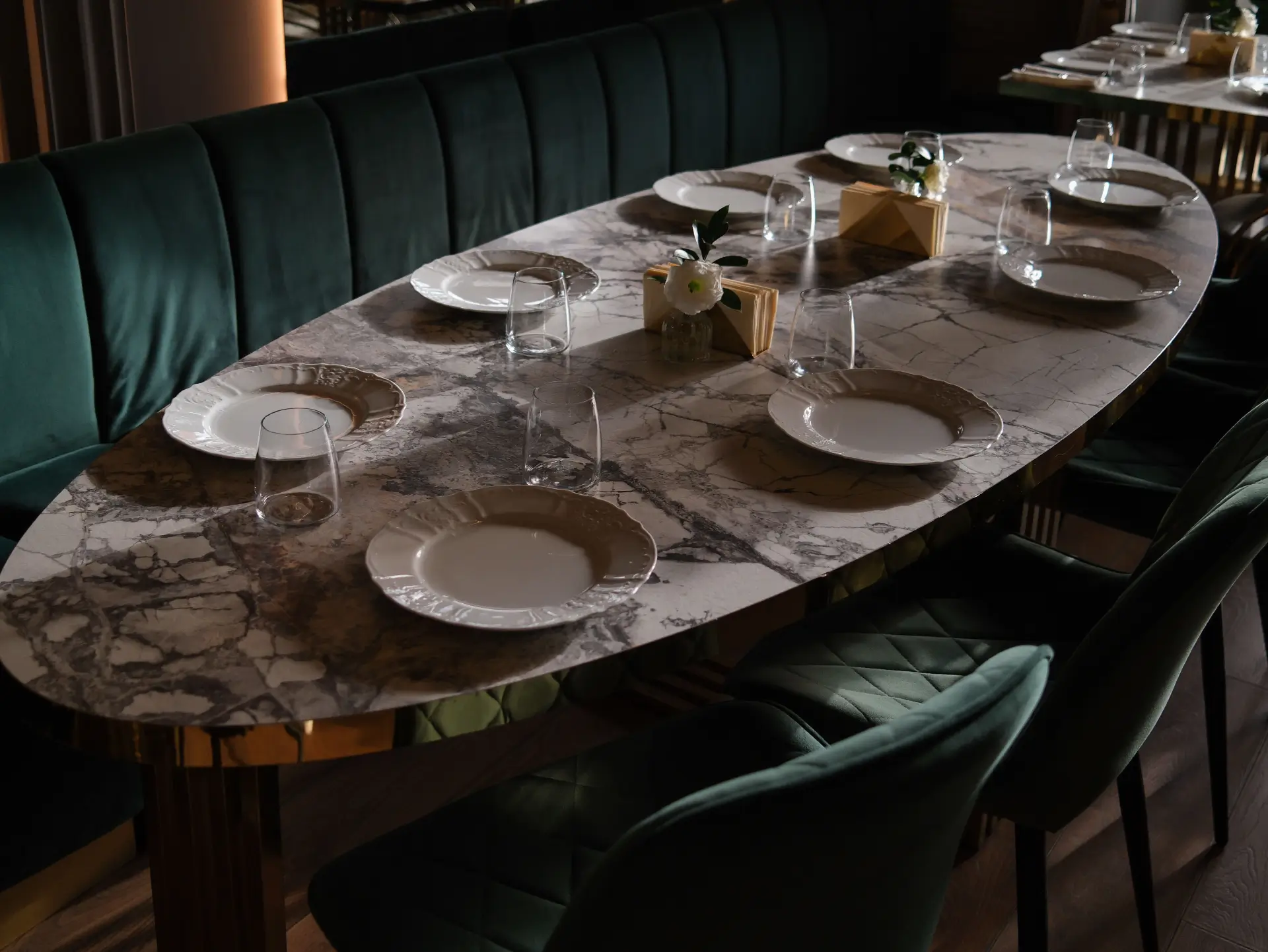 Marble dining room table with green velvet chairs
